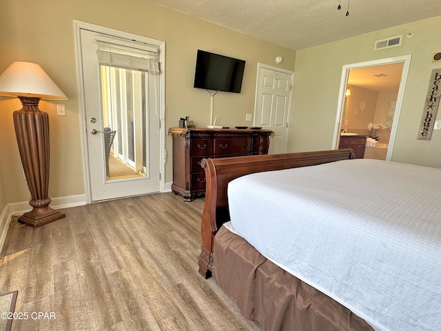 bedroom with baseboards, light wood-style flooring, and visible vents