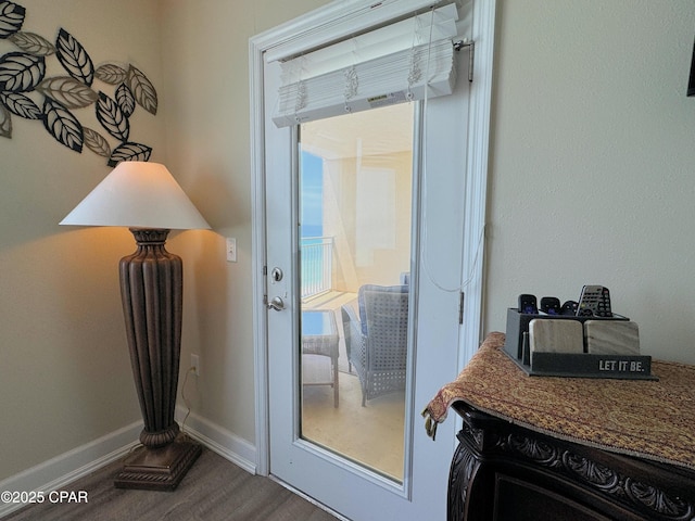 doorway to outside featuring dark wood-type flooring and baseboards