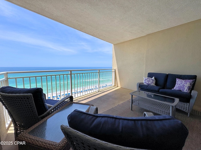 balcony featuring a beach view, a water view, and an outdoor living space