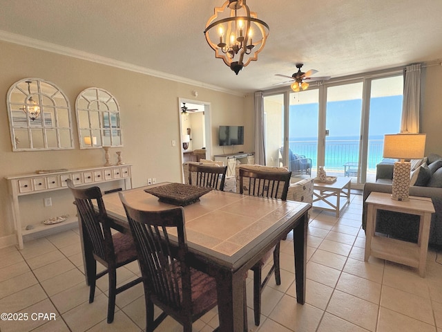 dining space with ornamental molding, light tile patterned flooring, floor to ceiling windows, a textured ceiling, and ceiling fan with notable chandelier