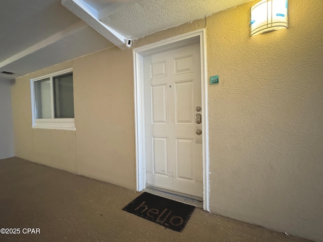 view of exterior entry featuring visible vents and stucco siding