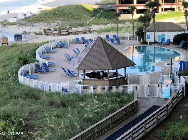 community pool with a gazebo and fence