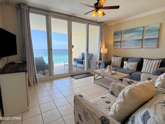 living room featuring a water view, ceiling fan, ornamental molding, and light tile patterned flooring
