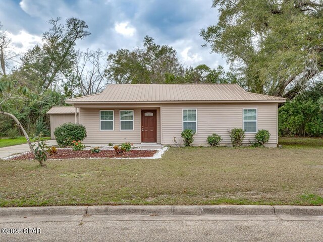 ranch-style house with an attached garage, driveway, a front yard, and metal roof