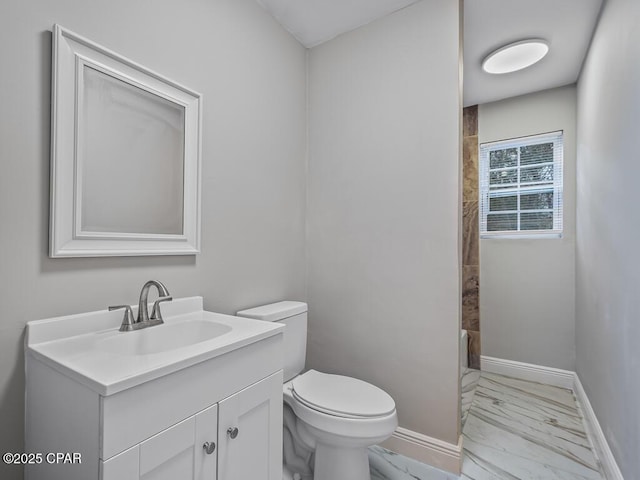 bathroom with a shower with curtain, marble finish floor, toilet, vanity, and baseboards