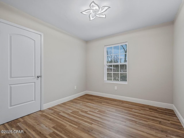unfurnished room featuring wood finished floors and baseboards
