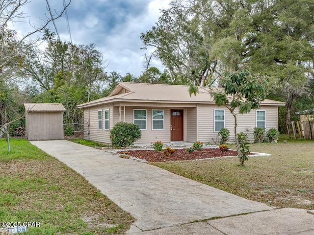 ranch-style house with an outdoor structure, concrete driveway, a storage unit, and a front yard