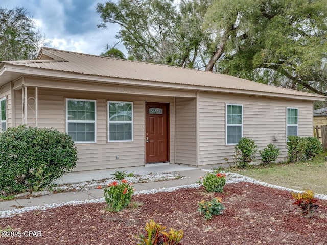 ranch-style house featuring a porch and metal roof