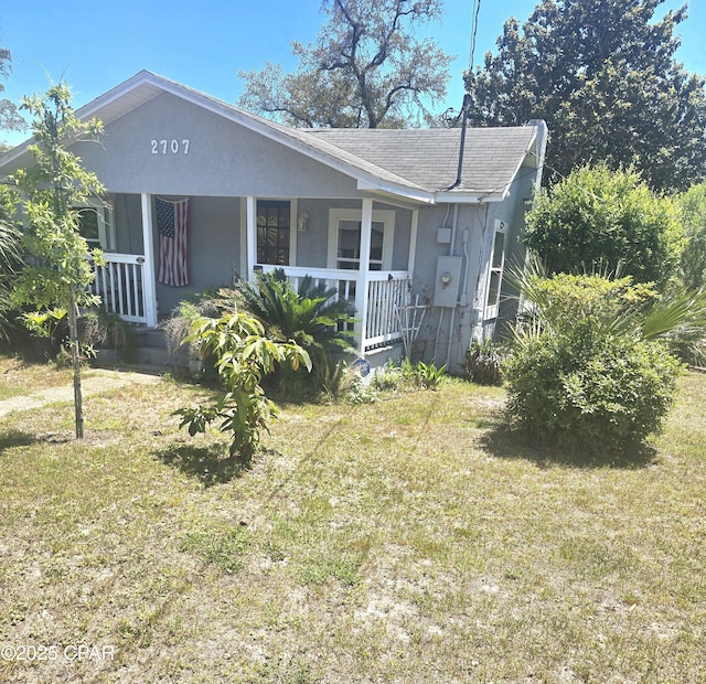 2707 W 18th St, Panama City, FL 32405 - view of front of property with a shingled roof, a front lawn, stucco siding, and covered porch