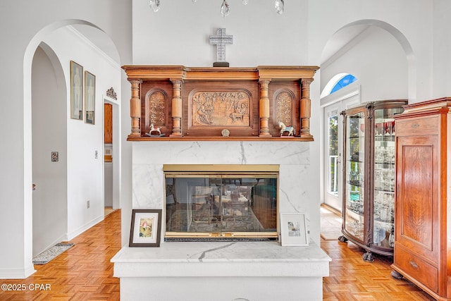 interior space with baseboards, ornamental molding, and a towering ceiling