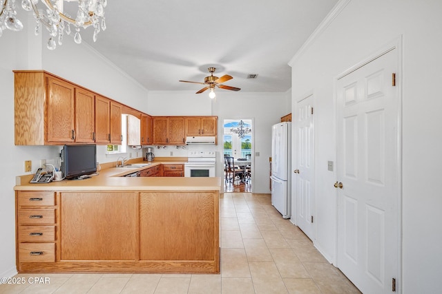 kitchen with crown molding, a peninsula, ceiling fan with notable chandelier, and white appliances