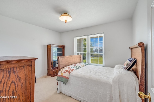 bedroom featuring baseboards and light carpet
