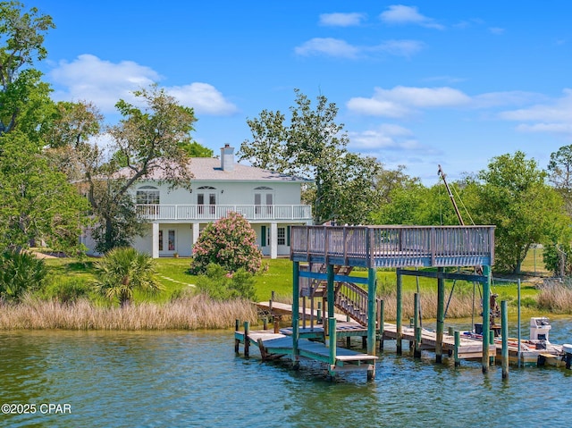 dock area featuring a deck with water view and a yard