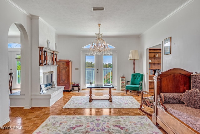 living area with visible vents, arched walkways, a textured ceiling, and baseboards
