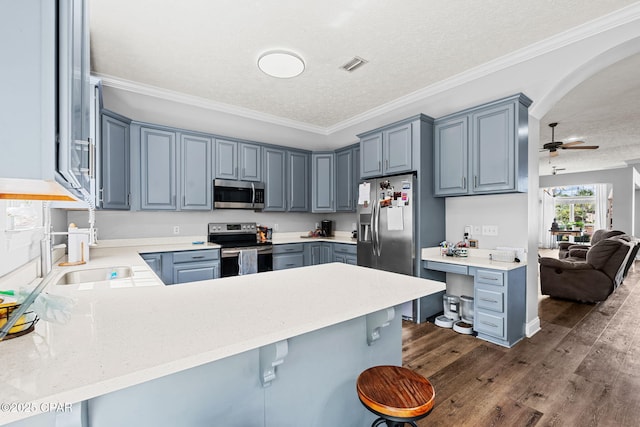 2501 Pelican Bay Dr, Panama City, FL 32408 - kitchen with stainless steel appliances, a peninsula, a textured ceiling, a sink, and arched walkways