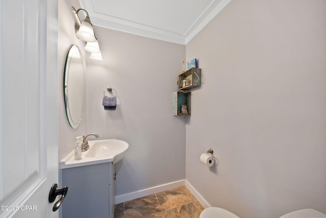 half bath featuring baseboards, ornamental molding, toilet, and vanity