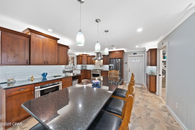 kitchen with a spacious island, stainless steel appliances, ornamental molding, backsplash, and baseboards