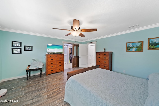 bedroom featuring a ceiling fan, crown molding, a closet, wood finish floors, and visible vents