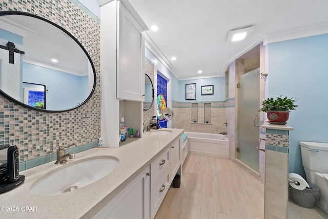 full bathroom with a sink, a shower stall, a bath, toilet, and ornamental molding