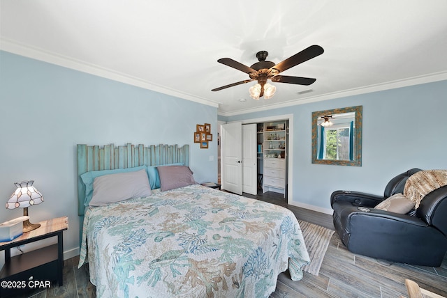 bedroom with a closet, crown molding, a ceiling fan, baseboards, and wood finished floors