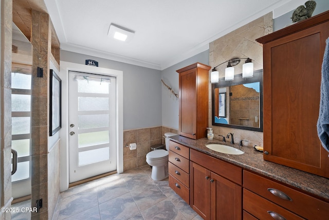 full bathroom featuring toilet, tile walls, walk in shower, crown molding, and vanity