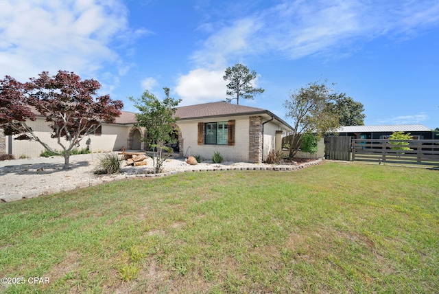 ranch-style house with fence, brick siding, a front yard, and a garage