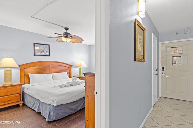 bedroom with baseboards, a ceiling fan, and wood finished floors
