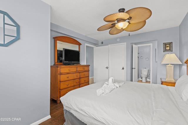 bedroom with a ceiling fan, visible vents, dark wood finished floors, baseboards, and connected bathroom