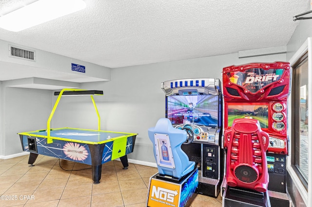 rec room featuring baseboards, a textured ceiling, visible vents, and tile patterned floors