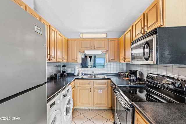 kitchen featuring a sink, washer / dryer, backsplash, and stainless steel appliances