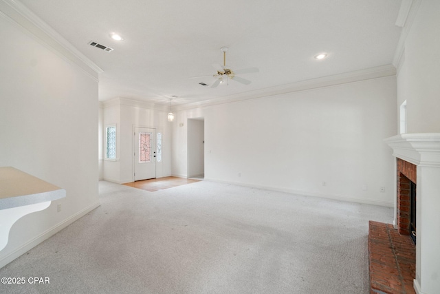 unfurnished living room featuring carpet, a fireplace, visible vents, a ceiling fan, and crown molding