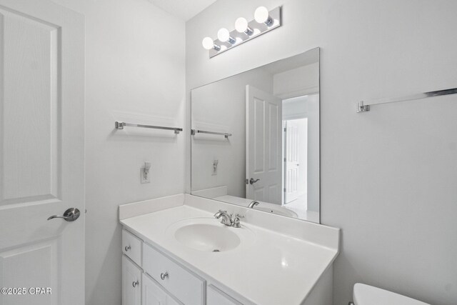 half bath featuring toilet and vanity