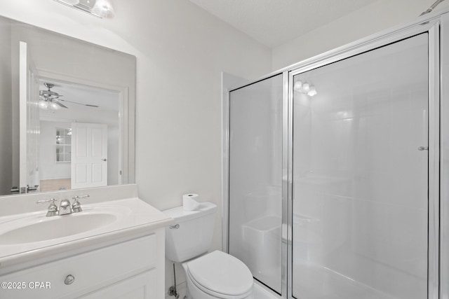 full bath with a stall shower, ceiling fan, toilet, and vanity