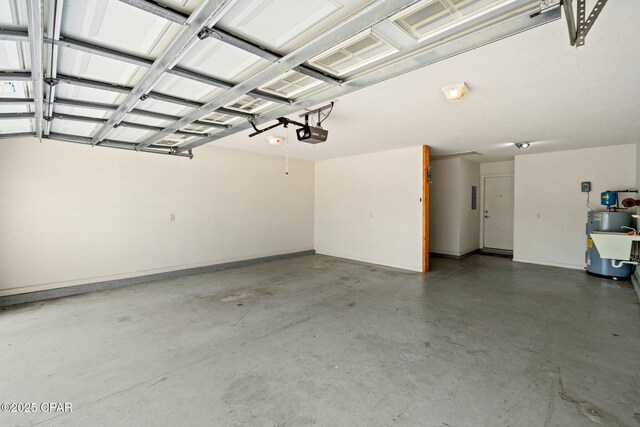 garage featuring baseboards, a garage door opener, and water heater