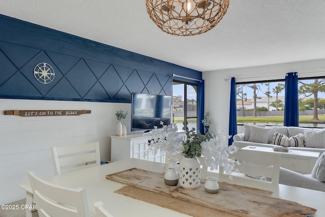 dining area with a textured ceiling and an inviting chandelier