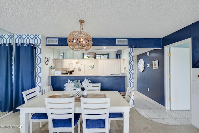 dining room featuring visible vents, a textured ceiling, and carpet floors