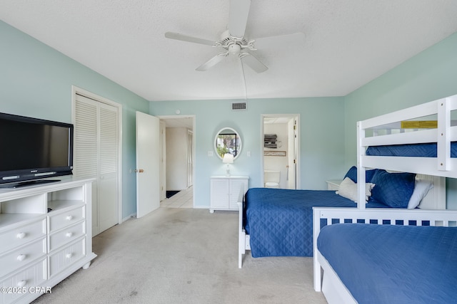 bedroom featuring connected bathroom, a ceiling fan, visible vents, baseboards, and light colored carpet