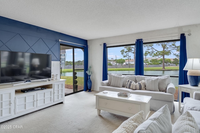 living room featuring carpet floors, a textured ceiling, and a water view