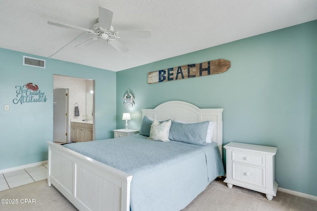 bedroom featuring a textured ceiling, visible vents, ensuite bathroom, baseboards, and a ceiling fan