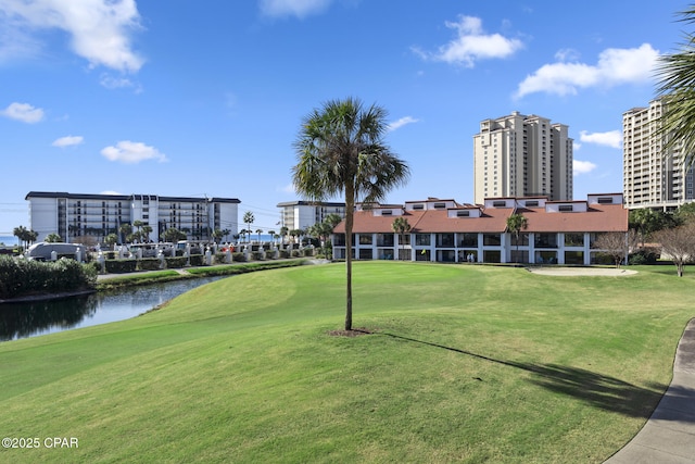 view of home's community featuring golf course view, a yard, and a water view