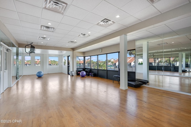 exercise room featuring visible vents, wood finished floors, and a drop ceiling
