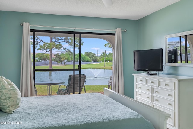 bedroom with access to exterior, ceiling fan, a textured ceiling, and multiple windows