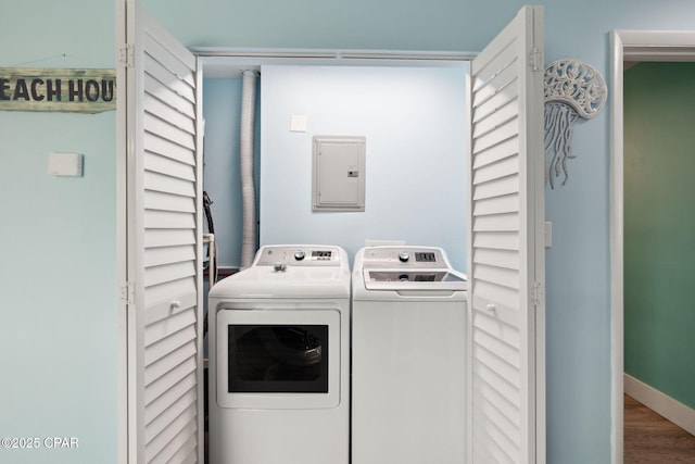 laundry area with laundry area, washing machine and dryer, wood finished floors, and electric panel