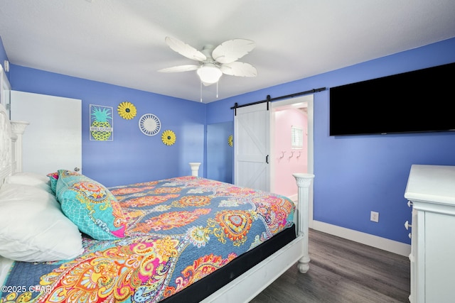 bedroom with a ceiling fan, baseboards, a barn door, and wood finished floors