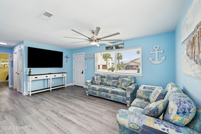 living room with visible vents, baseboards, ceiling fan, and wood finished floors