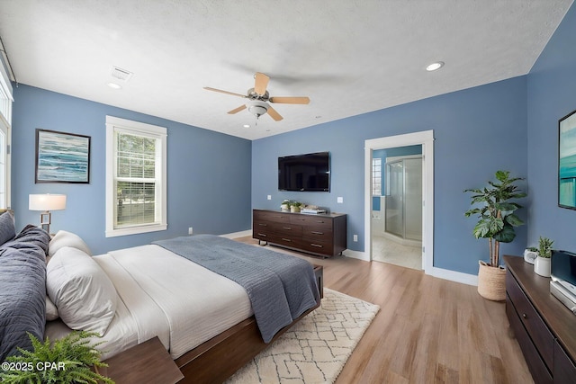 bedroom with light wood finished floors, a ceiling fan, baseboards, ensuite bath, and recessed lighting