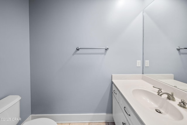 bathroom featuring vanity, toilet, baseboards, and tile patterned floors