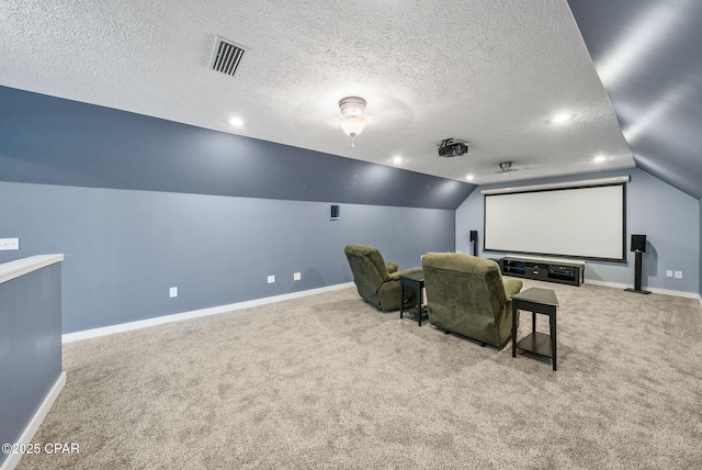 carpeted cinema featuring vaulted ceiling, a textured ceiling, visible vents, and baseboards
