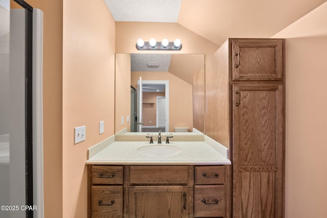bathroom with vanity, toilet, and lofted ceiling