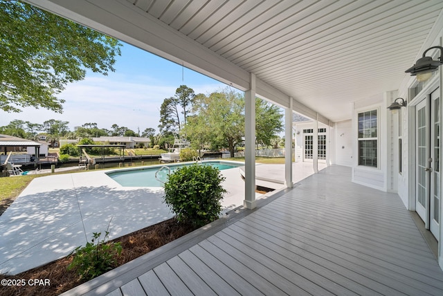 deck featuring a patio area, french doors, and a fenced in pool